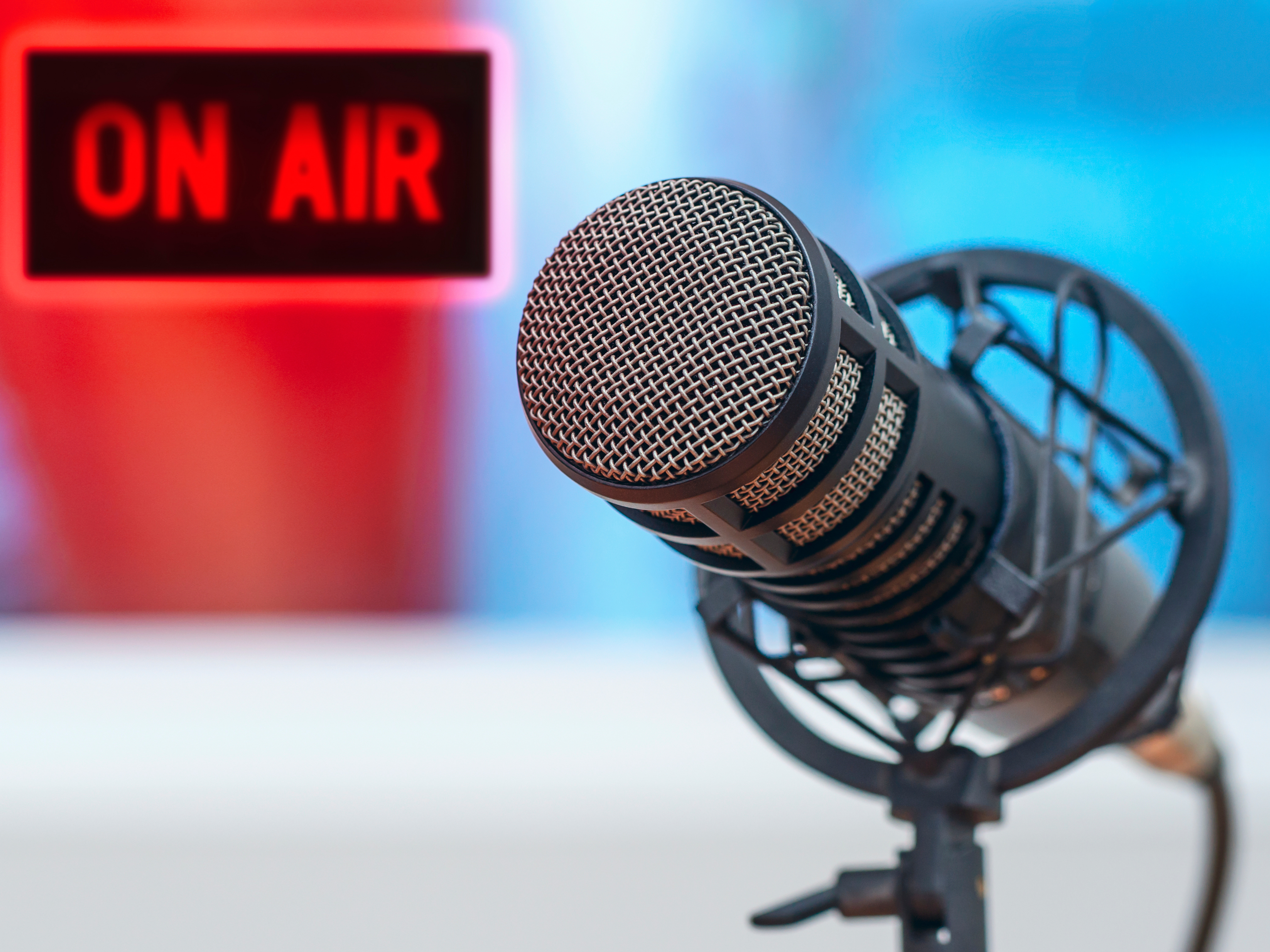 Studio microphone with a glowing red ON AIR sign