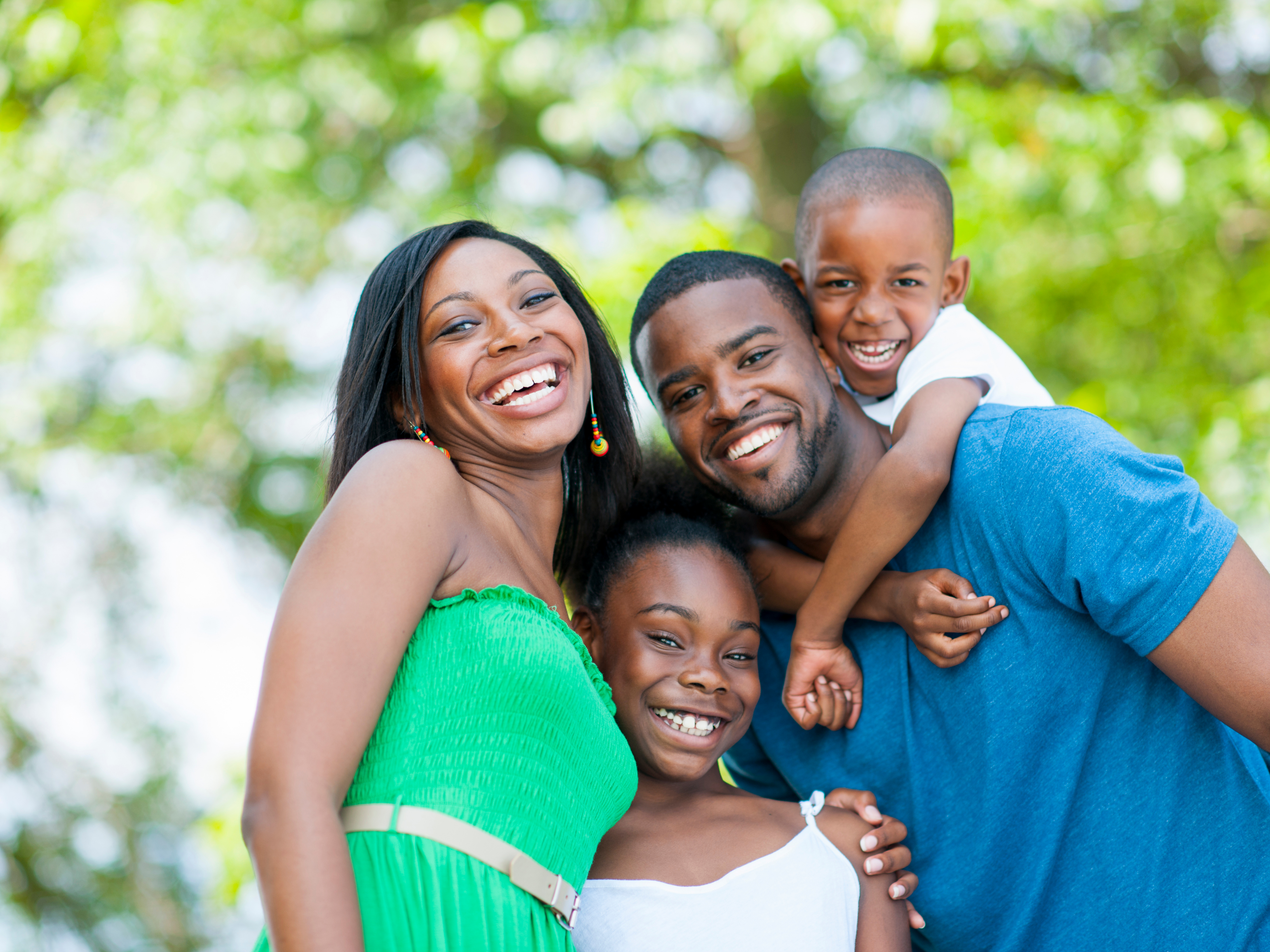 Family laughing together in a sunny park